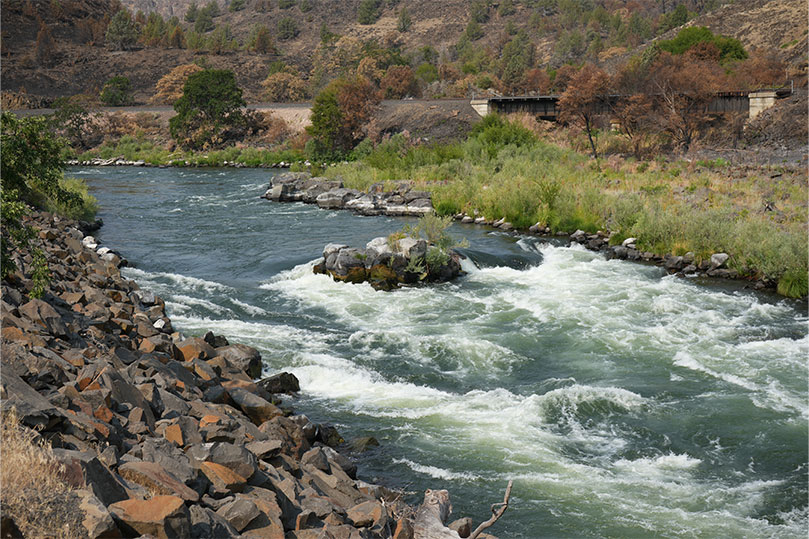 Flowing river and wrapping around large boulders